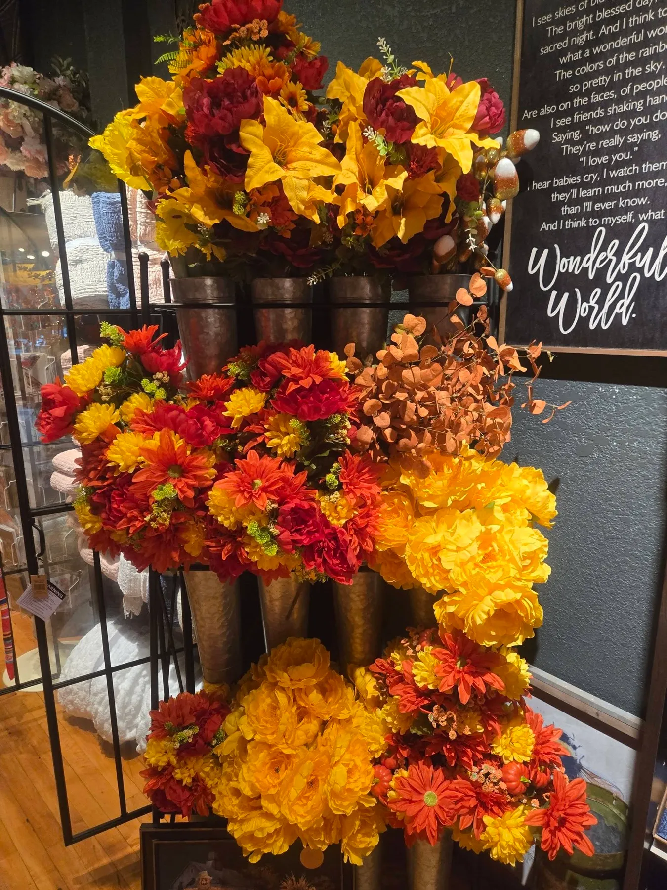 A wall of marigold and crimson florals in galvanized buckets